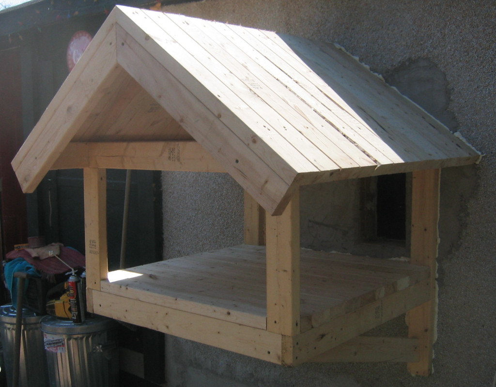 finishing homemade cat pen on wall outside